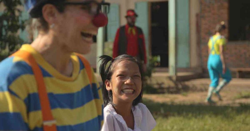 A girl laughs with a clown