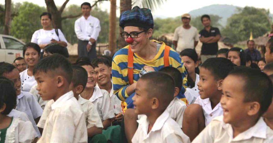 A clown shares a moment with an audience of young children in Myanmar.